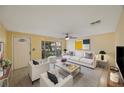 Bright living room with modern furniture, ceiling fan, and front door access at 15530 Morgan St, Clearwater, FL 33760