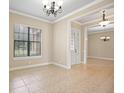 Open concept living room features tile floors, a decorative chandelier, and natural light at 15708 Oakleaf Run Dr, Lithia, FL 33547