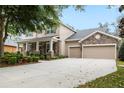 Charming home featuring stone accents, a covered front porch, and a three-car garage at 15912 Ternglade Dr, Lithia, FL 33547