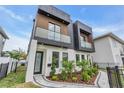 Stylish two-story home showcasing a landscaped front yard, a black wrought iron fence and a modern exterior at 1627 9Th N Ave, St Petersburg, FL 33713