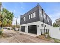 This modern home features a two-car garage with black doors and a white and black facade at 1627 9Th N Ave, St Petersburg, FL 33713