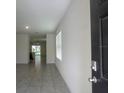 Inviting entryway with neutral tile floors leading to an open floor plan at 17014 Oval Rum Dr, Wimauma, FL 33598