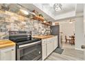 Updated kitchen boasts butcher block counters, brick backsplash, floating shelves, and stainless steel appliances at 1844 Bough Ave # C, Clearwater, FL 33760