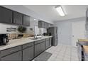 Modern kitchen with stainless steel appliances, gray cabinets, and ample counter space at 20191 Rutherford Ave, Port Charlotte, FL 33952