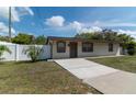 Inviting single-story home showcasing a well-maintained lawn and a concrete driveway at 6213 Sheldon Rd, Tampa, FL 33615