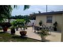 Outdoor patio area with an elegant dining set and beautiful landscaping at 6213 Sheldon Rd, Tampa, FL 33615