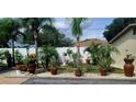 Landscaped front yard featuring a well-manicured garden with potted plants and a decorative statue at 6213 Sheldon Rd, Tampa, FL 33615
