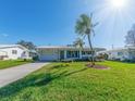 Inviting single-story home with a well-manicured lawn and beautiful palm trees enhancing curb appeal at 14336 93Rd Ave, Seminole, FL 33776