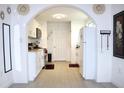 Open kitchen layout with white cabinets, modern appliances, and an arched doorway at 1701 E New Orleans Ave, Tampa, FL 33610