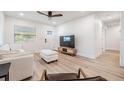 Bright living room with hardwood floors, a ceiling fan, and a comfortable white sofa at 2004 N Grady Ave, Tampa, FL 33607