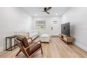 Bright living room with hardwood floors, a ceiling fan, and a comfortable white sofa at 2004 N Grady Ave, Tampa, FL 33607