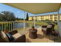 Relaxing balcony view with wicker chairs overlooking the pond, trees, and building at 2220 Spanish Dr # 4, Clearwater, FL 33763