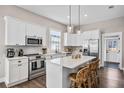 Modern kitchen with white cabinetry, stainless steel appliances, quartz countertops, and an island with seating at 3002 N 16Th St, Tampa, FL 33605