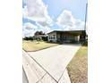 Wide angle view of a single-story home with a well-maintained lawn and covered parking at 34344 Timberland Blvd, Wesley Chapel, FL 33543