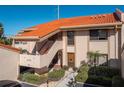 Charming condo building featuring a red tile roof, a staircase leading to the units, and a well-maintained landscaped yard at 4790 Brittany S Dr # 105, St Petersburg, FL 33715