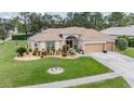 Inviting single-story home with landscaped front yard, two-car garage, and charming curb appeal at 5088 Championship Cup Ln, Spring Hill, FL 34609
