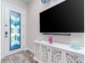 Bright living room features a decorative glass front door and a modern entertainment center at 5526 14Th S Ave, Gulfport, FL 33707