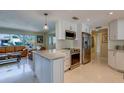 Bright, open-concept kitchen with stainless steel appliances, a center island, and white cabinets at 809 Royal Dr, Largo, FL 33770
