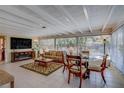 Cozy sun room with tile floors, a beamed ceiling, plenty of windows and a dining area at 809 Royal Dr, Largo, FL 33770