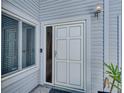 Close-up of a white front door with a window and an electronic doorbell, complemented by a side window at 9718 Tiffany Oaks Ln # 12, Tampa, FL 33612