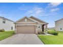 Single-story home with well-maintained lawn, neutral exterior, and an attached two-car garage at 10864 Penny Gale Loop, San Antonio, FL 33576