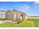 Well-maintained single-story home boasting a manicured lawn and serene lake views at 10864 Penny Gale Loop, San Antonio, FL 33576