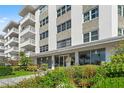 Apartment building entrance with manicured garden and glass doors at 1100 N Shore Ne Dr # 304, St Petersburg, FL 33701