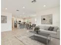 Open-concept living room featuring a modern sofa, stylish coffee table, and an inviting kitchen with a breakfast bar at 1226 Mumford Ct, Zephyrhills, FL 33540