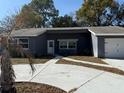 Single Gathering home featuring a one-car garage, front door, double windows, driveway and palm tree at 12607 Blackberry Row, Hudson, FL 34667