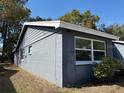 Corner view of the exterior featuring double windows, and grey paint at 12607 Blackberry Row, Hudson, FL 34667