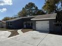 Single Gathering home featuring a one-car garage, front door, double windows, driveway and lawn at 12607 Blackberry Row, Hudson, FL 34667