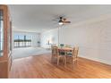 Cozy dining area with wood floors, a ceiling fan, and an adjacent living space with views of the water at 131 Bluff View Dr # 409, Belleair Bluffs, FL 33770