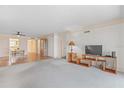 Spacious living room with carpet flooring, a large window, and access to the dining area at 131 Bluff View Dr # 409, Belleair Bluffs, FL 33770