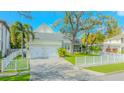 Charming home featuring a well-manicured lawn, two-car garage and white picket fence at 148 Chippewa Ave, Tampa, FL 33606