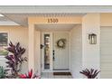 Close up of the front door with decorative wreath and sidelight window at 1510 Lakeside Dr, Dunedin, FL 34698