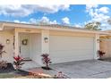 Front exterior showcasing a large garage, decorative wreath, and manicured landscaping at 1510 Lakeside Dr, Dunedin, FL 34698