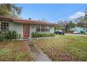 Charming single-story home with a red door and lush landscaping at 1920 E Clifton St, Tampa, FL 33610