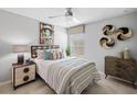 Cozy bedroom with a comfortable queen-sized bed, ceiling fan, natural light, and a stylish accent wall at 23335 Van Buren Ave, Port Charlotte, FL 33981