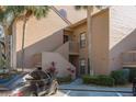 Exterior front daytime view of condo showing architecture, stairs to unit, parking, and landscaping at 351 Windrush Loop, Tarpon Springs, FL 34689