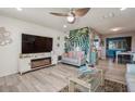 Relaxing living room featuring a cozy electric fireplace, hardwood floors, and ceiling fan at 3715 98Th N Ave # 3, Pinellas Park, FL 33782