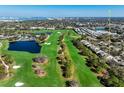 An aerial view captures the golf course and pond of the community with condo buildings in the foreground at 39 Pelican Pl, Belleair, FL 33756