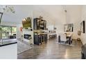Bright open-concept living room with fireplace, dining area, bar, and kitchen perfect for entertaining at 39 Pelican Pl, Belleair, FL 33756