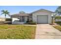 Inviting single-story home with attached garage and landscaped front yard with green lawn at 4582 Fox Lake Ct, Clearwater, FL 33762