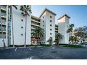 Exterior shot of the condo featuring a circular drive, tropical landscaping, and ample parking at 4830 Osprey S Dr # 305, St Petersburg, FL 33711