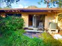 Inviting backyard patio with lush greenery, outdoor seating and sliding glass doors at 5603 Sycamore N St # 5603, St Petersburg, FL 33703