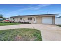 Single-story home featuring an attached garage, driveway, and front yard at 6310 57Th N Ave, St Petersburg, FL 33709