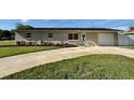 Traditional home with well-manicured landscaping, long driveway, and single-car garage at 6310 57Th N Ave, St Petersburg, FL 33709
