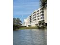 View of the condo building from the lake with balconies and landscaped grounds at 6425 Shoreline Dr # 10506, St Petersburg, FL 33708