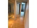 Bright hallway featuring mirrored closets and wood floors leading to an adjacent room at 6425 Shoreline Dr # 10506, St Petersburg, FL 33708