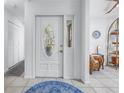 Bright foyer with a decorative door, tiled floor, and view into the adjacent living spaces at 992 San Carlos Ne Ct, St Petersburg, FL 33702